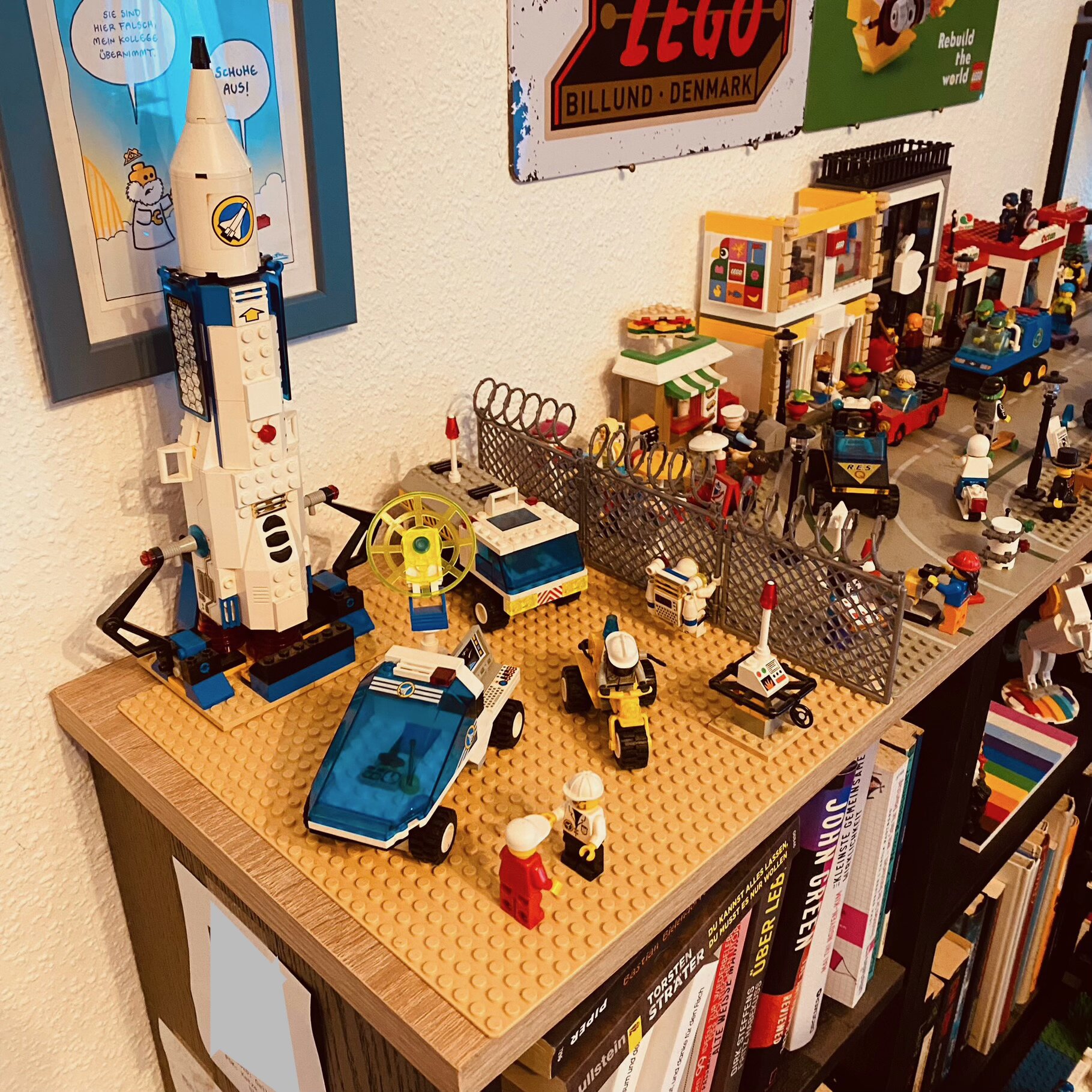 Eine Raketenstartrampe und Fahrzeuge aus der LEGO-Space-Port-Reihe hinter einem Stacheldraht-Zaun direkt an der Hauptstraße